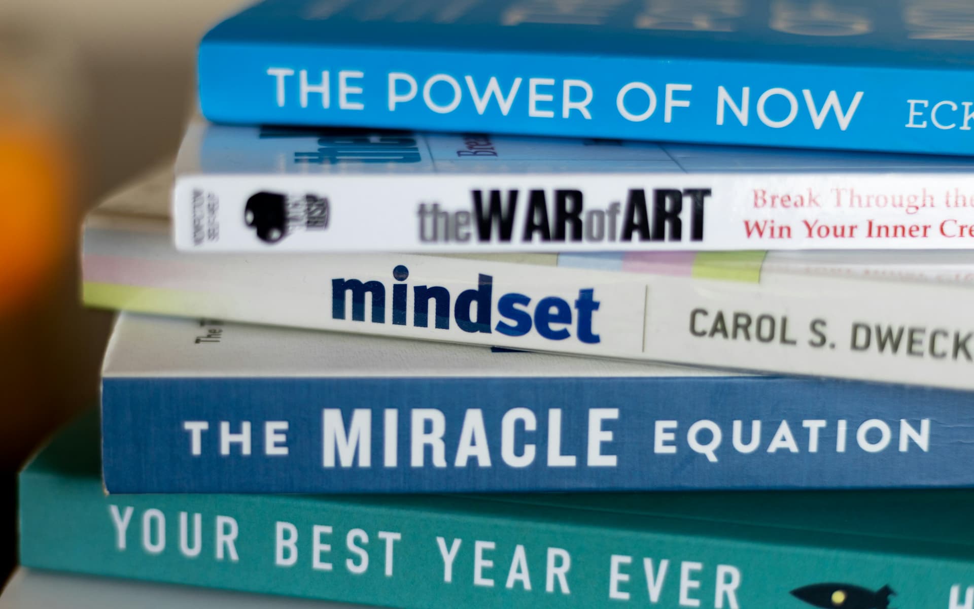 Person reading a self-help book, lost in reflection